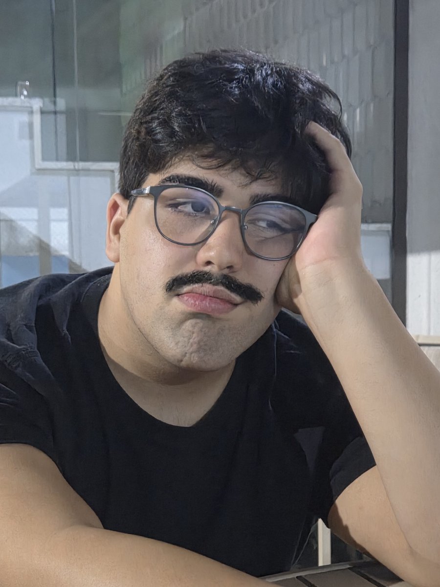 Diego de óculos e camiseta preta, com a cabeça apoiada na mão